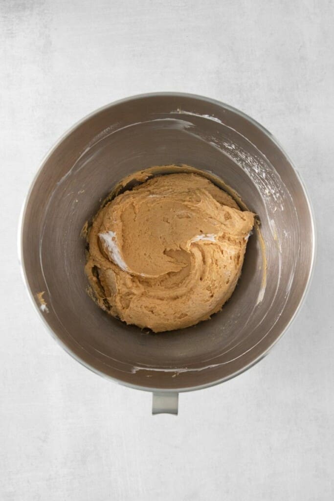 Folding in half of cool whip into peanut butter cream cheese mixture in a mixing bowl.