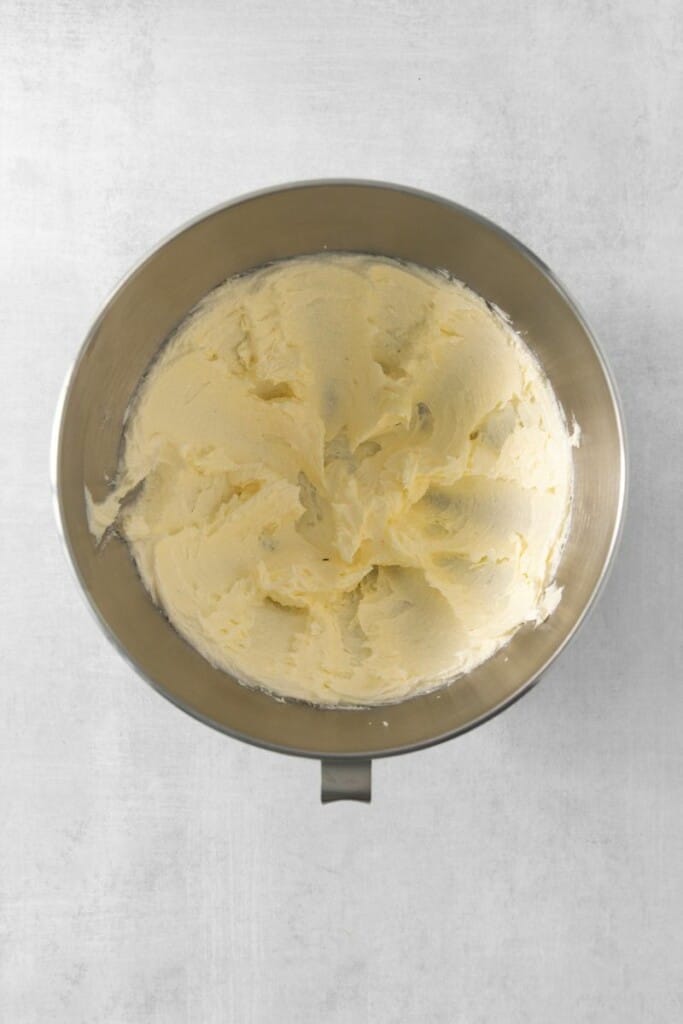 Combining butter, sugar and almond extract in a mixing bowl.