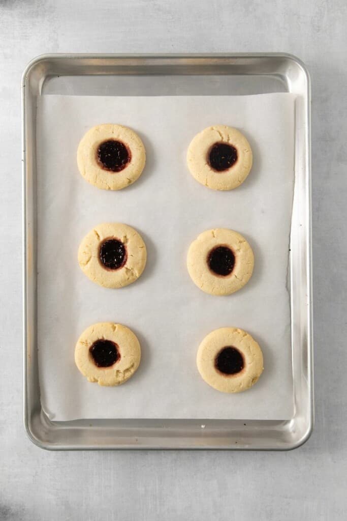 Filling the thumbprints in six cookies with raspberry filling.