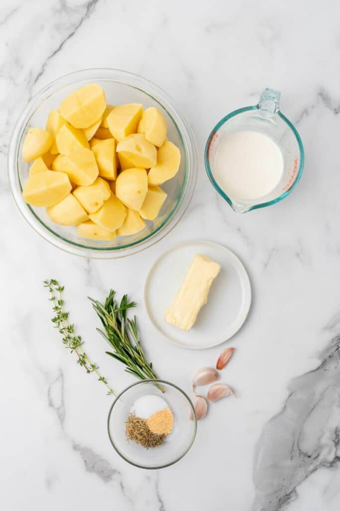 Ingredients needed to prepare mashed potatoes seasoned with rosemary and garlic.