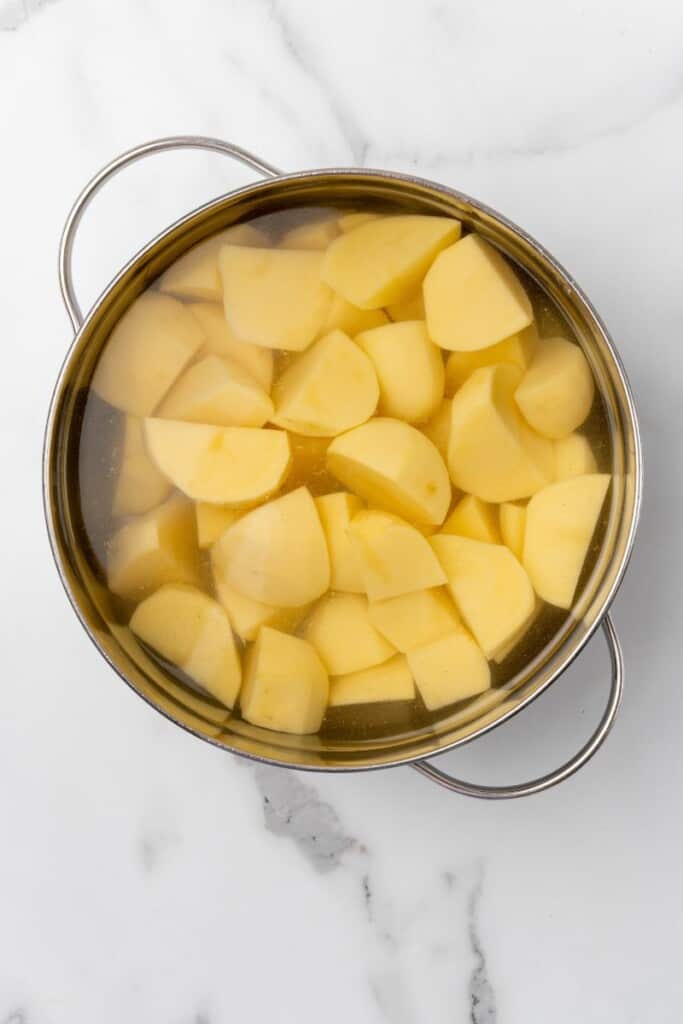 Cut up potatoes in a stockpot of water.