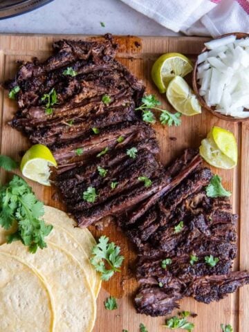 Slices of skirt steak on a wooden cutting board.