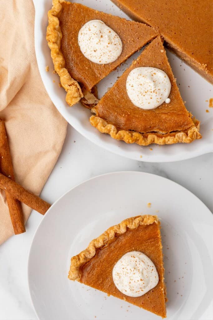 Overhead view of slices of sweet potato pie topped with whipped cream.