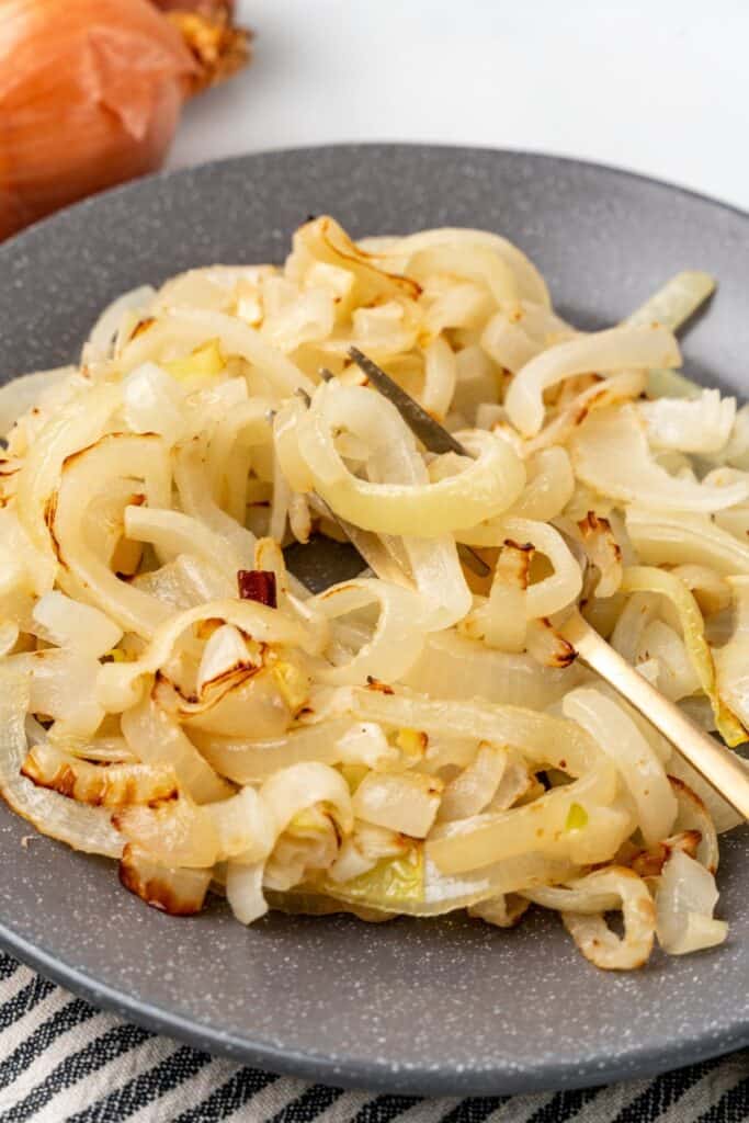 Air fried onions on a plate with a fork inside them.