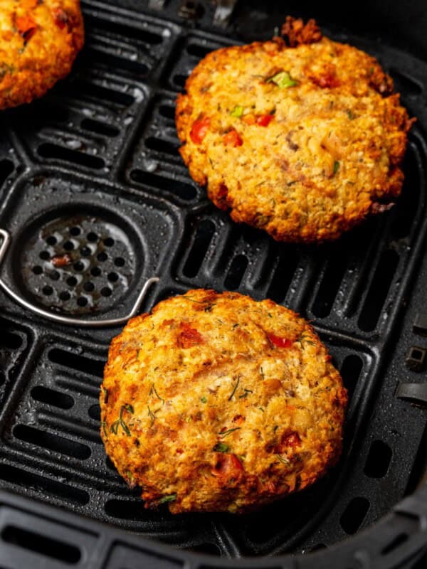 Close up of salmon patties in air fryer basket that are cooked.