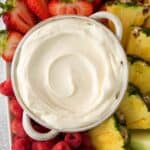 3 ingredient fruit dip with marshmallow fluff in a bowl with strawberries, apples, and pineapple chunks surrounding it.
