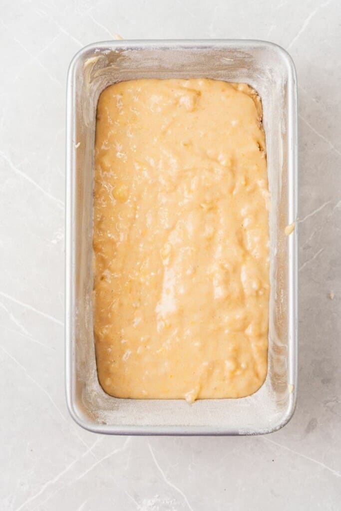 Mixed banana bread batter poured into a loaf baking pan.