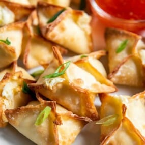 air fried wontons on a plate with dipping sauce