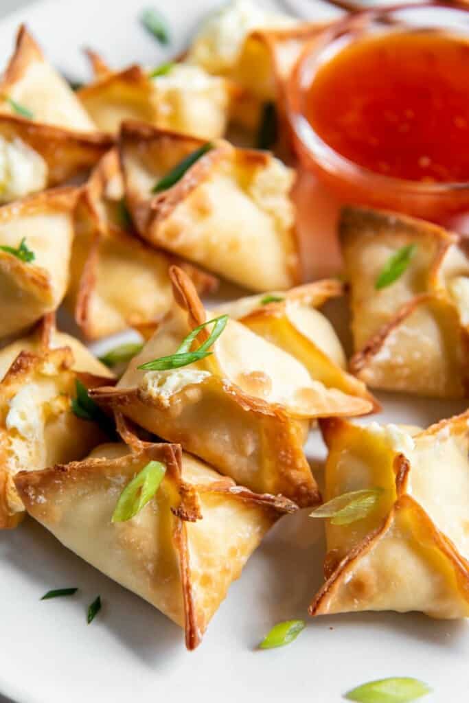 air fried wontons on a plate with dipping sauce 