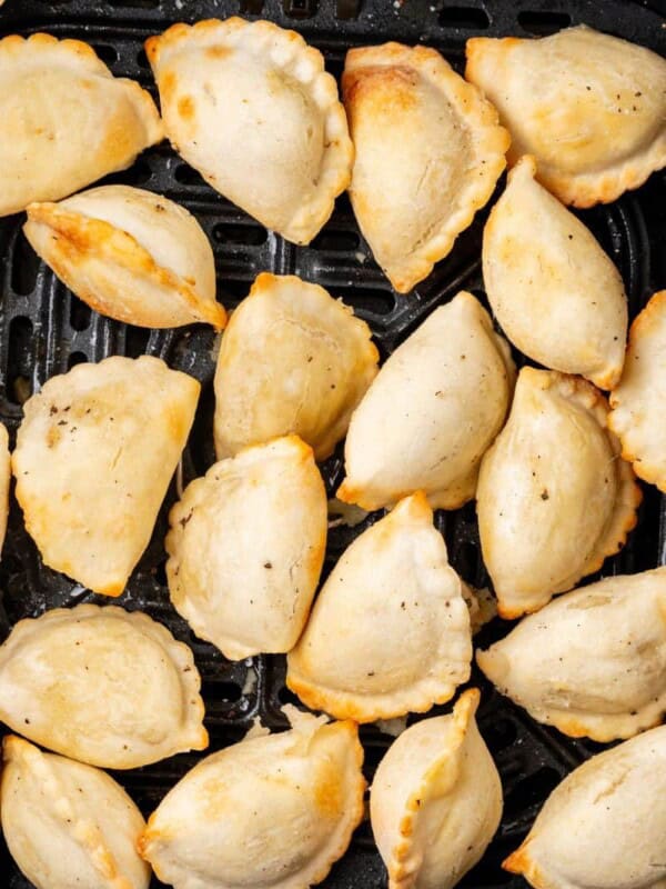 golden brown pierogies in an air fryer basket