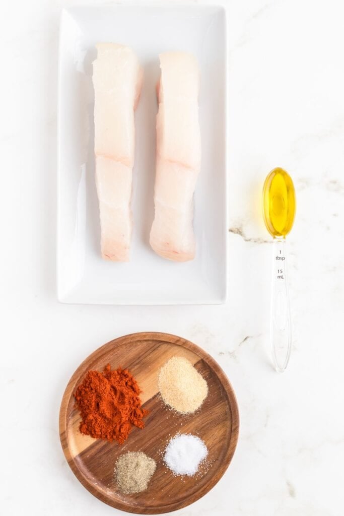 Ingredients needed to make air fryer tilapia: halibut fillets, olive oil, paprika, garlic powder, salt, and pepper.