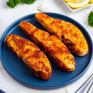 Three air fryer halibut fillets on a blue plate.