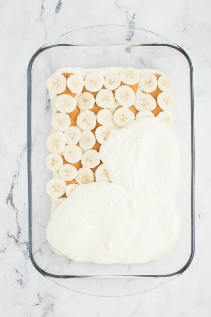 adding remaining layers to banana pudding with condensed milk.