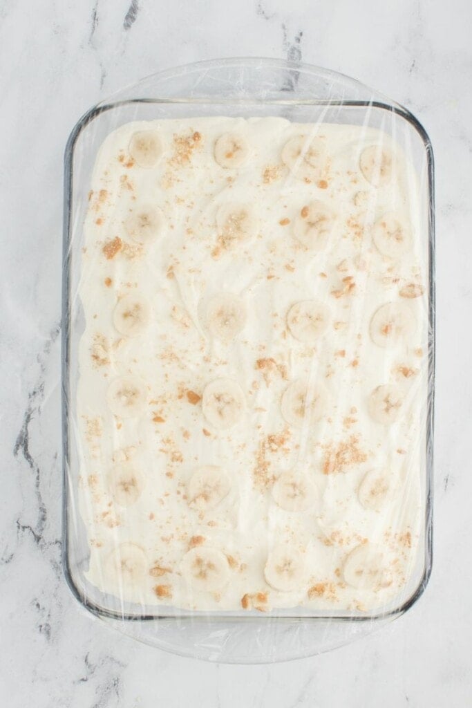 Adding food safe plastic wrap over casserole dish.