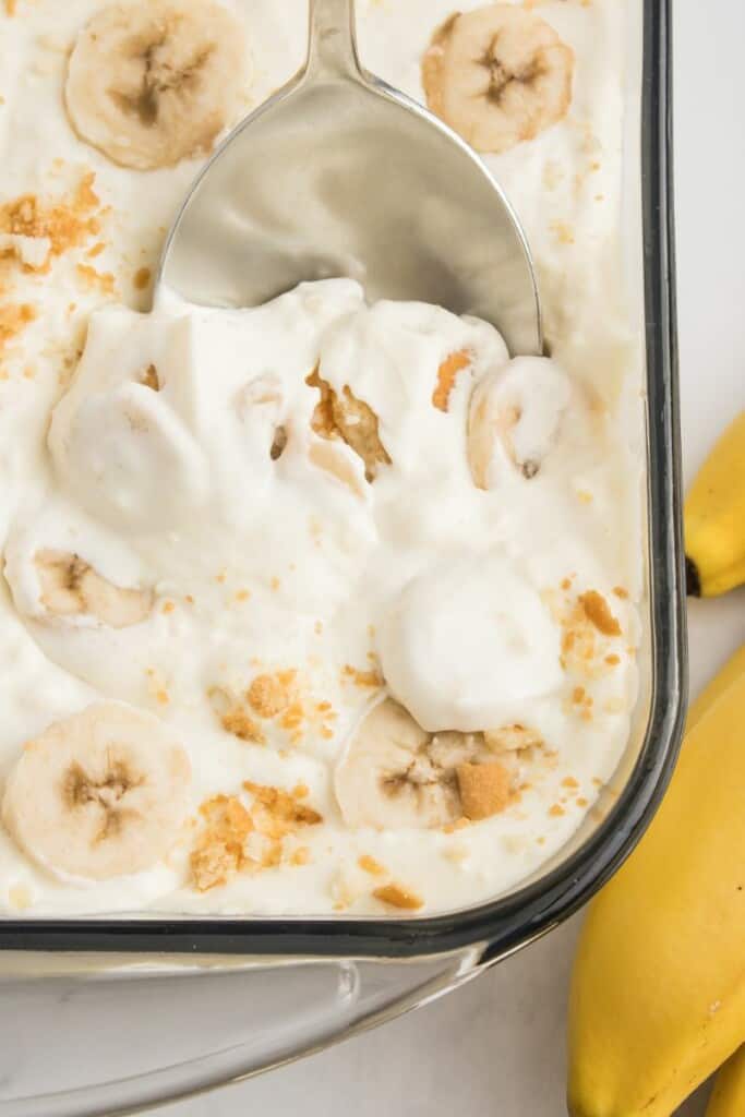 Closeup of banana pudding with condensed milk with a spoon in it