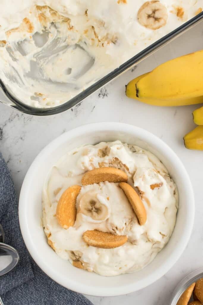 a bowl full of easy banana pudding with freshly sliced bananas and vanilla cookies.