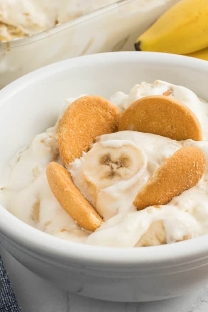 close up of vanilla pudding with bananas and whipped topping.