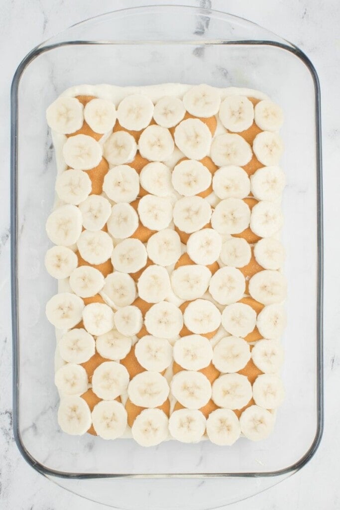 add the vanilla pudding to the casserole dish with banana slices and vanilla wafer cookies.