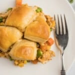 A plate of biscuit topped chicken pot pie with a fork.