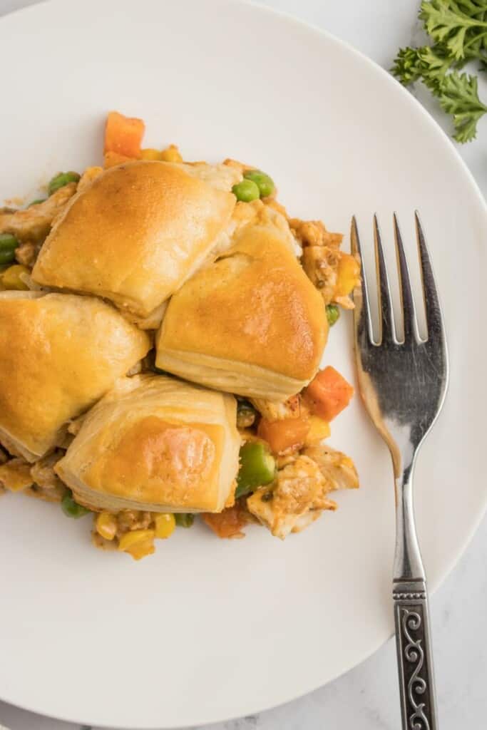 A plate of biscuit topped chicken pot pie with a fork.