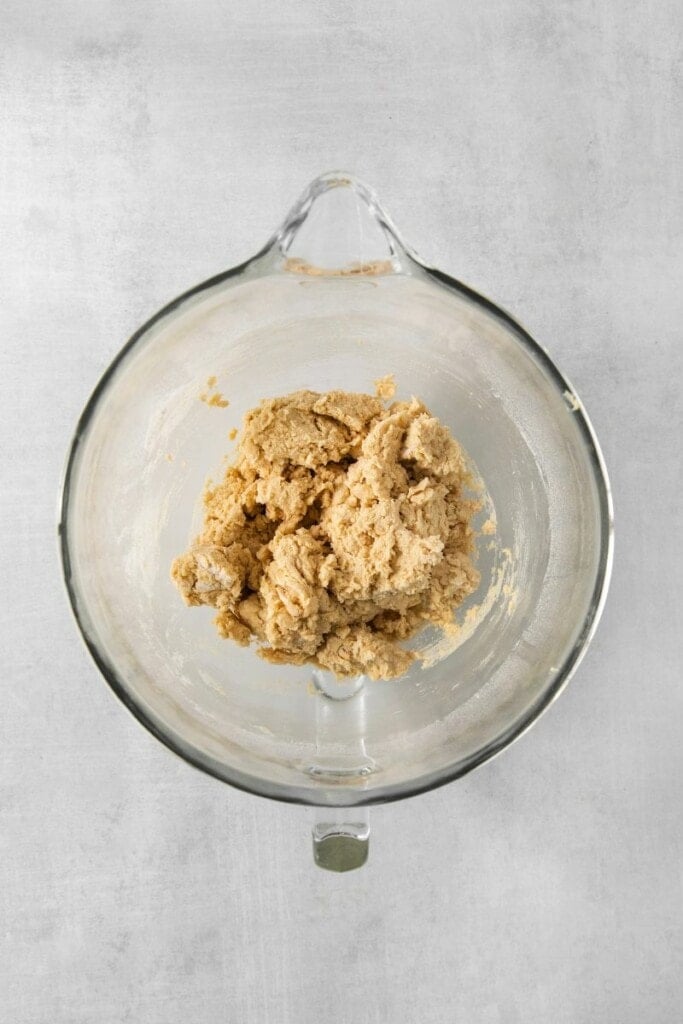 Cookie dough in a clear mixing bowl.