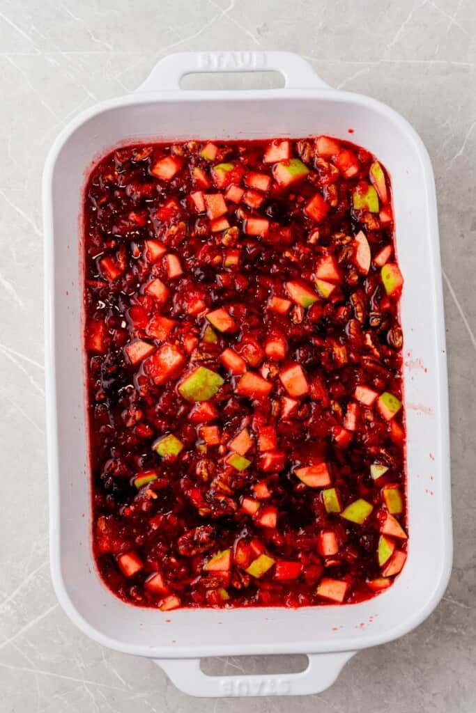 Fully combined jello salad ingredients transferred from mixing bowl to a baking dish.