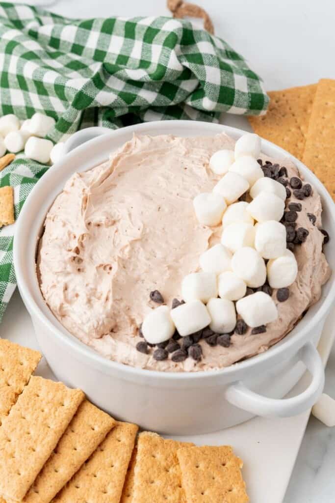 Hot cocoa dip in a serving dish with marshmallow garnish.