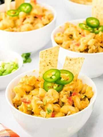 three bowls of mexican macaroni and cheese topped with jalapeño peppers