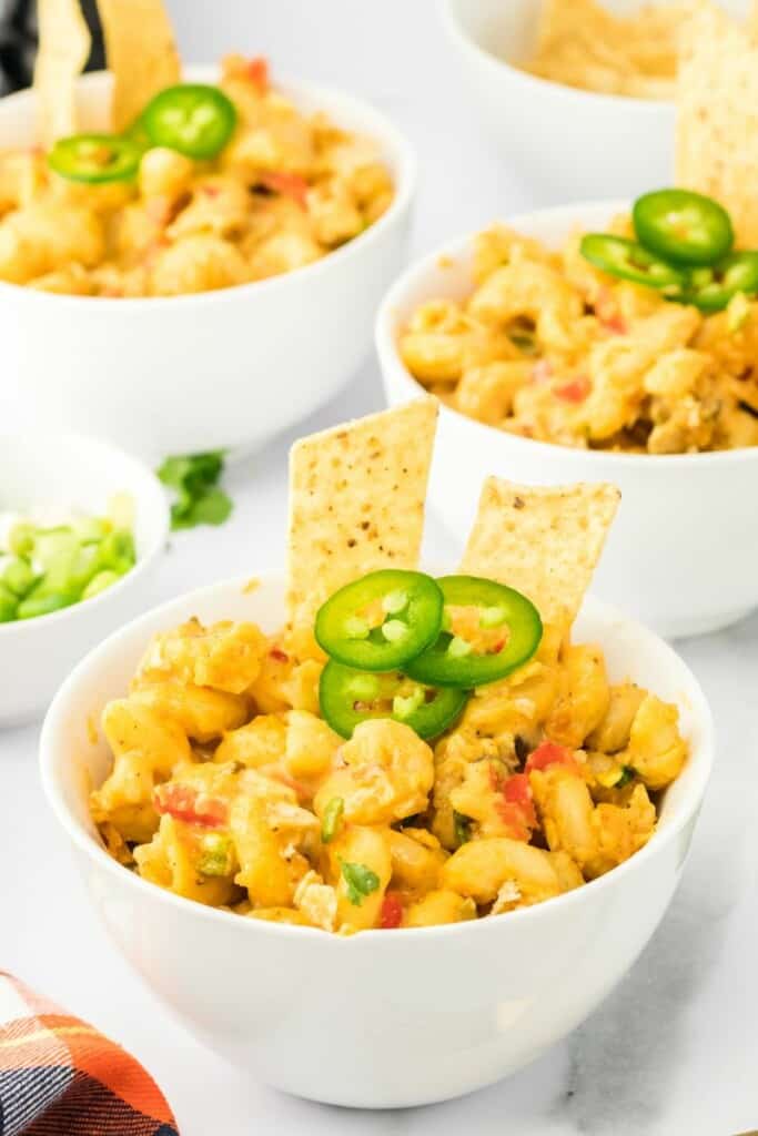 three bowls of mexican macaroni and cheese topped with jalapeño peppers