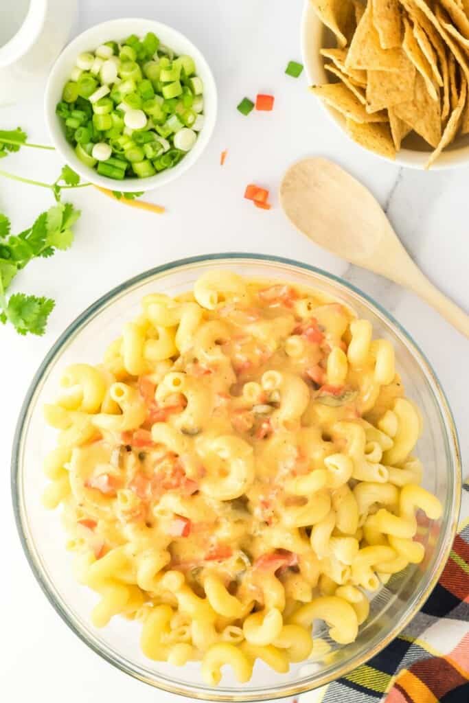 tossing cooked macaroni pasta with cheese sauce