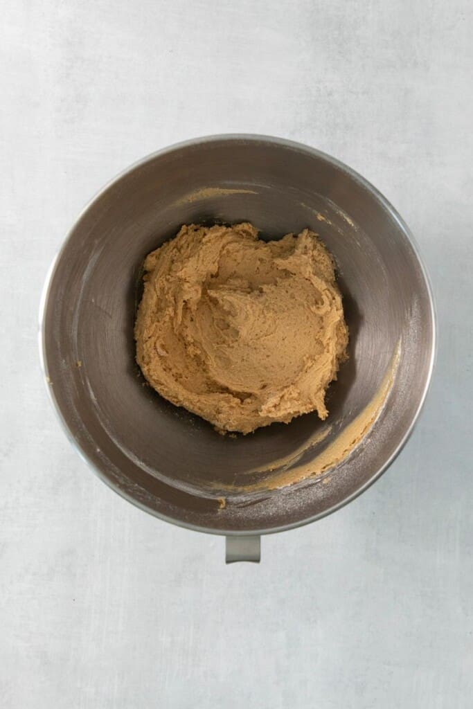 Combining the wet ingredients for chocolate chip peanut butter cookies in a mixing bowl.