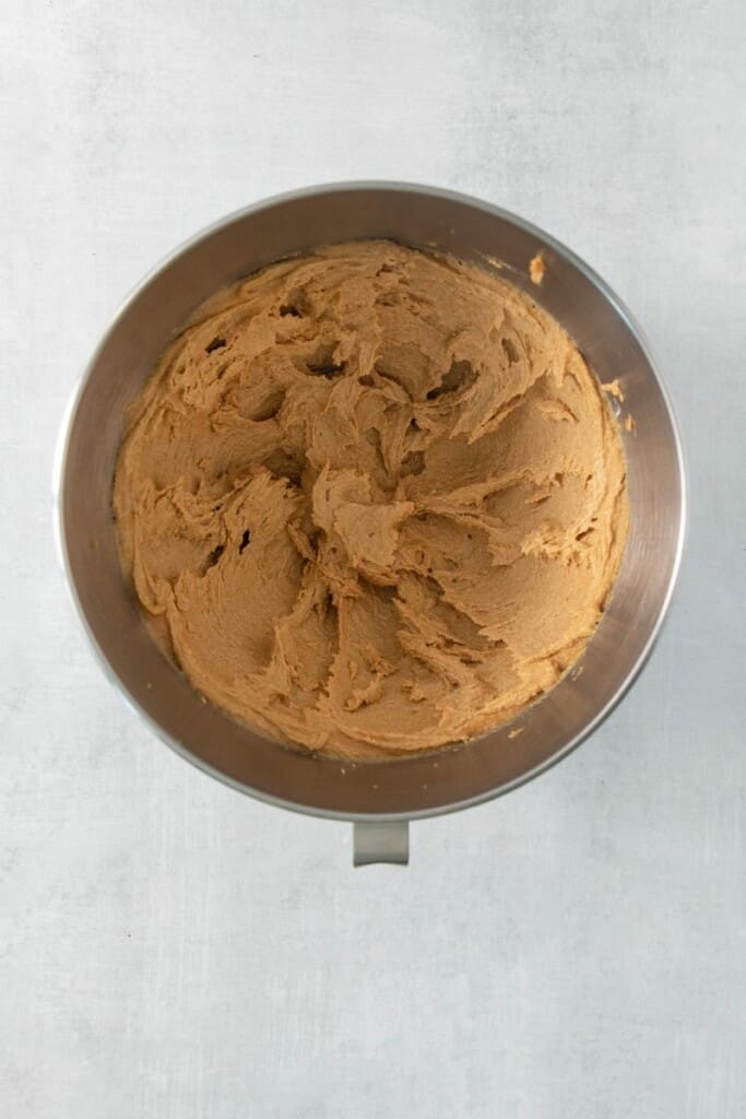 Combining wet and dry ingredients for chocolate chip peanut butter cookies in a mixing bowl.