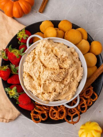 overhead shot of pumpkin dip with cool whip served with fruits and cookies