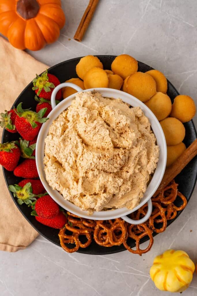 overhead shot of pumpkin dip with cool whip served with fruits and cookies