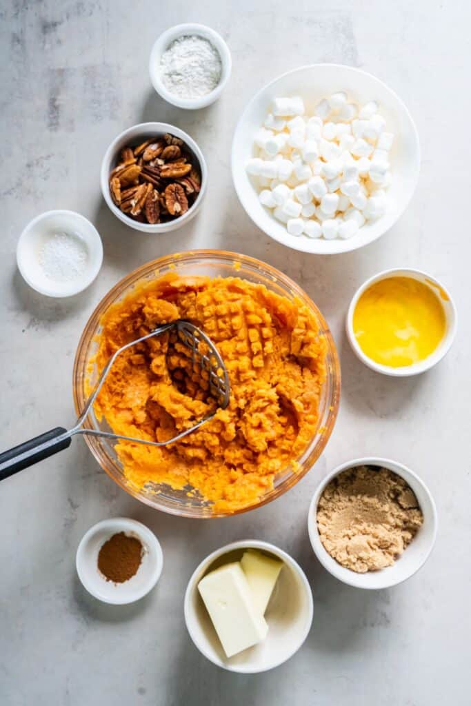 Mashing the canned yams in a clear glass bowl.