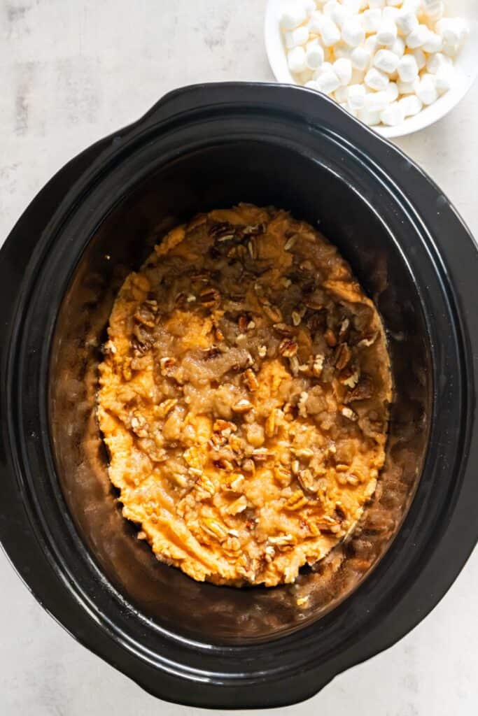 The canned yams mixture and pecans on top to make a sweet potato casserole in the crock pot.