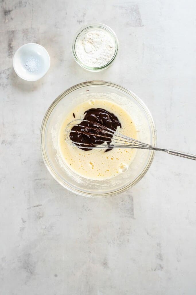 whisking together eggs and chocolate mixture.