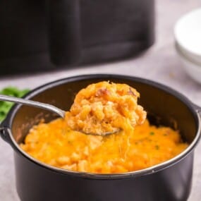 serving a scoop of air fried mac and cheese with a spoon.