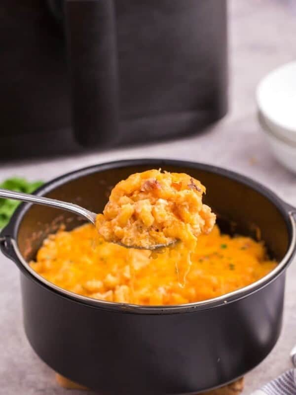 serving a scoop of air fried mac and cheese with a spoon.