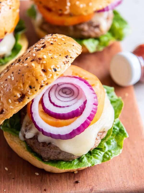 a cooked frozen turkey burger in a bun with cheese and toppings.