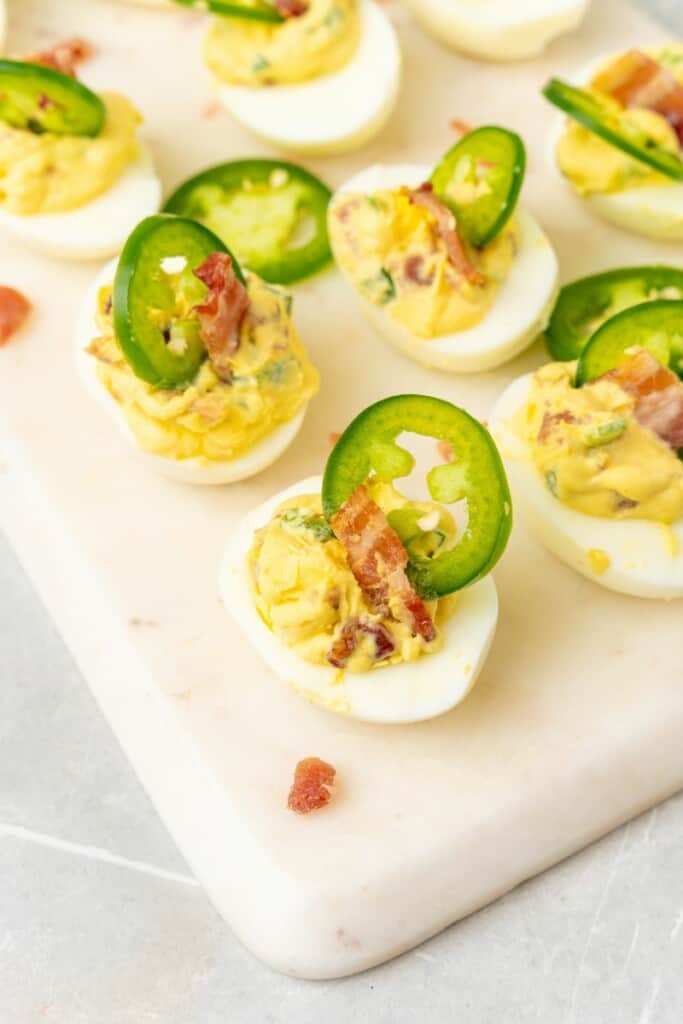 bacon jalapeno deviled eggs on a white platter 