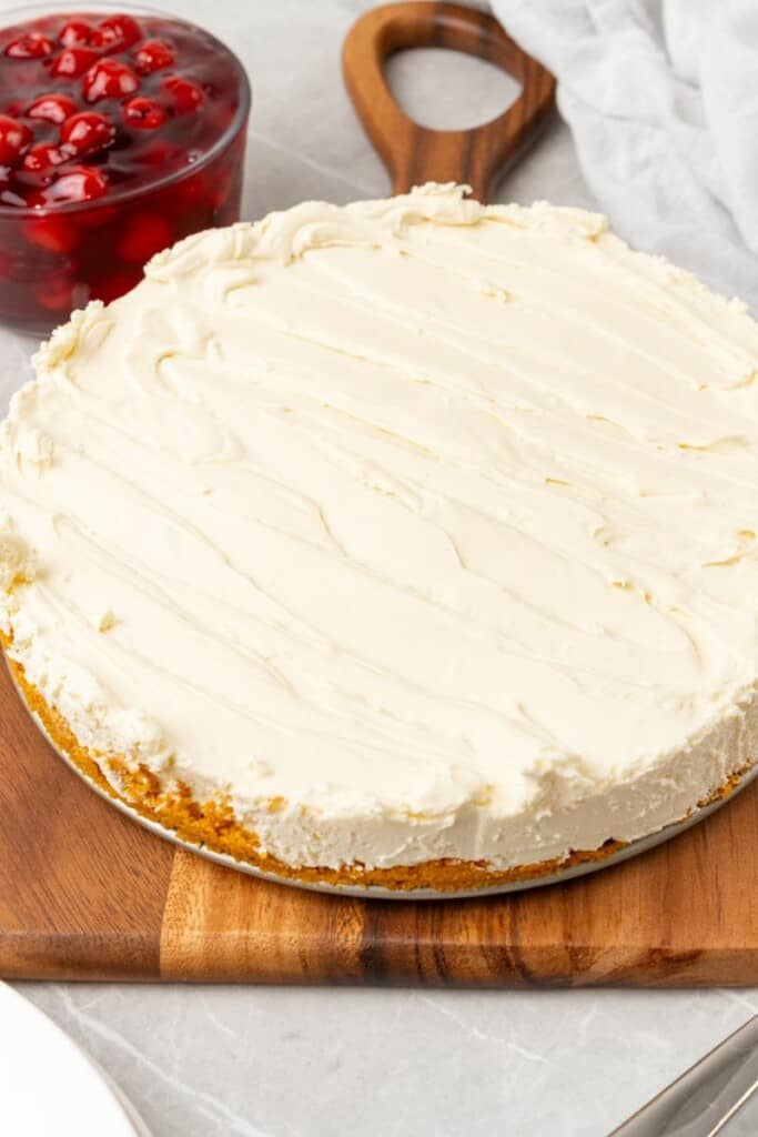 a chilled whole cheesecake on a cutting board