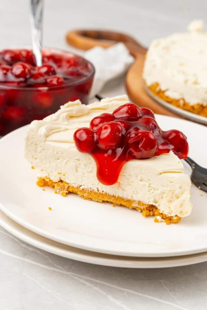 side view of a slice of no bake cheesecake with cherries