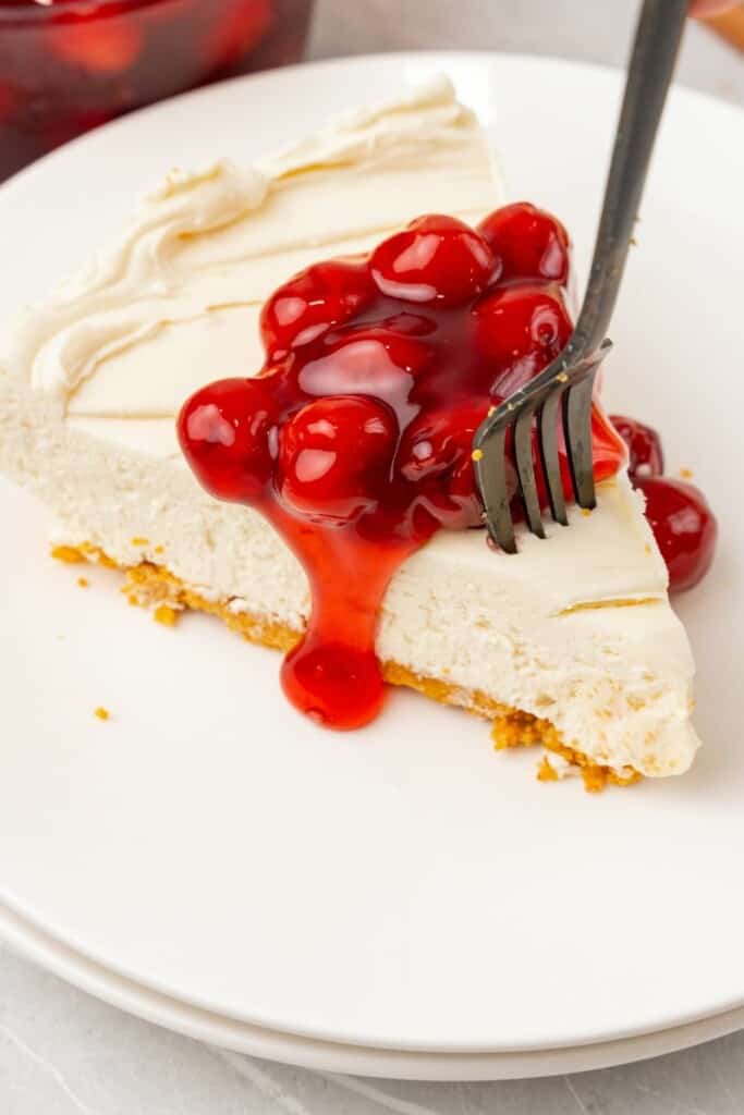 taking a bite out of cool whip cheesecake slice with a fork 