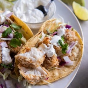 air fryer fish tacos in a corn tortilla with sour cream.