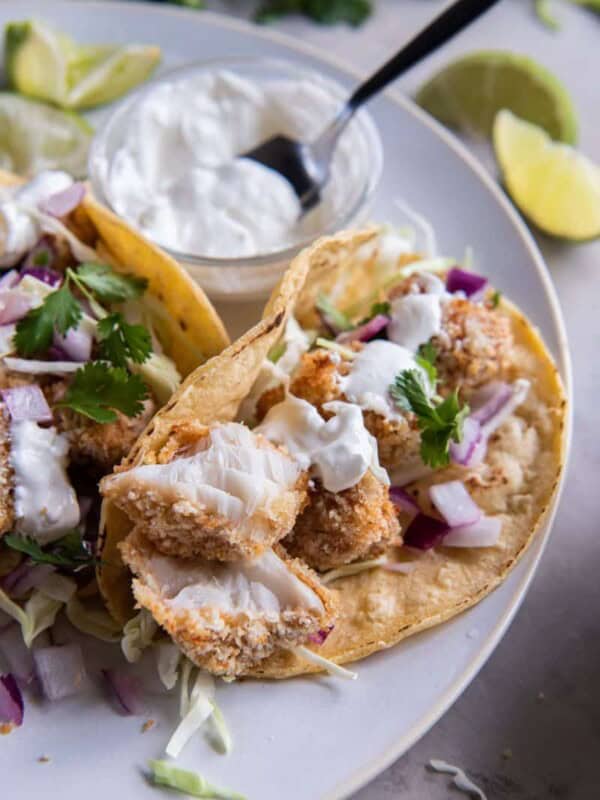 air fryer fish tacos in a corn tortilla with sour cream.