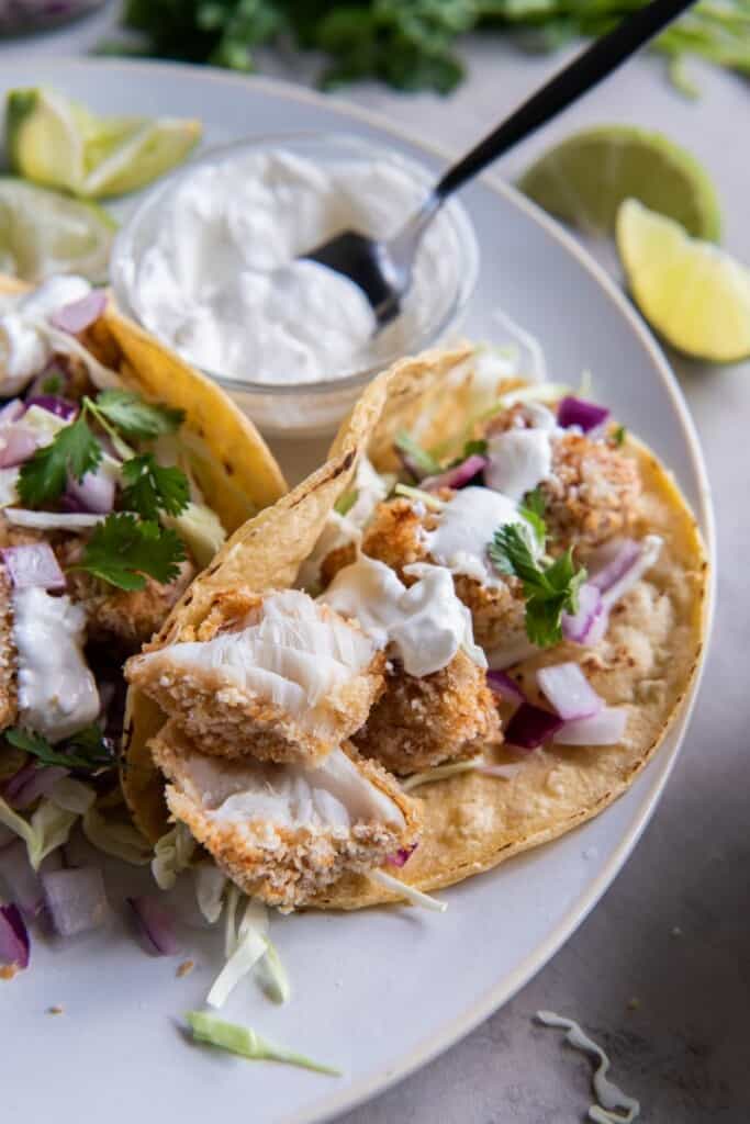 air fryer fish tacos in a corn tortilla with sour cream. 