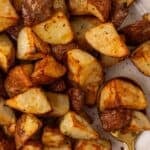air fryer red potatoes cooked on a white plate with a spoon.