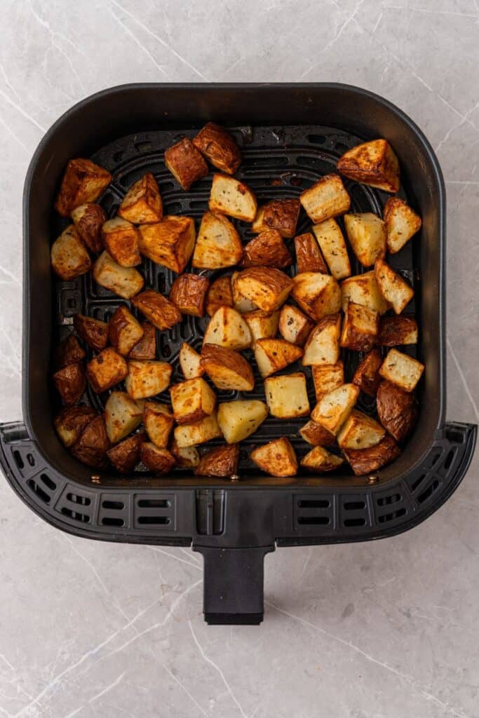 Cooked red potatoes in an air fryer basket from overhead.