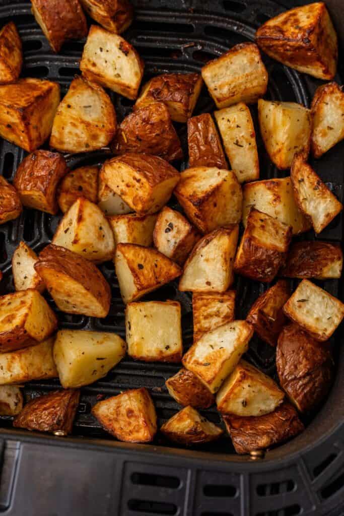 Close up of the air fryer red potatoes in the air fryer basket.